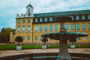 Karlsruhe şehrindeki güzel Alman kalesi mavi gökyüzü ve yeşil bitkilerin arka planına karşı.