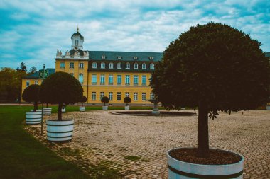 Karlsruhe şehrindeki güzel Alman kalesi mavi gökyüzü ve yeşil bitkilerin arka planına karşı.