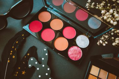 Göz falı paletleri, çiçekler, bardaklar, tavşan, tüy ve çiçekler siyah kağıt üzerinde