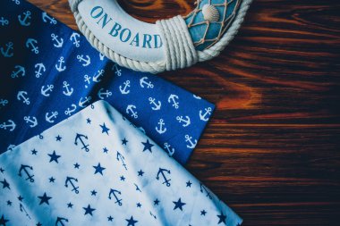 Lifebuoy, denizyıldızı ve ahşap kahverengi arka planda çapa izi kumaşı. Yaz mevsimi