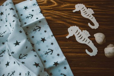 Kumaşa dayanak noktası, ahşap kahverengi arka planda denizatları.