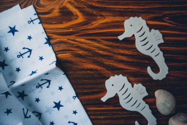 Kumaşa dayanak noktası, ahşap kahverengi arka planda denizatları.