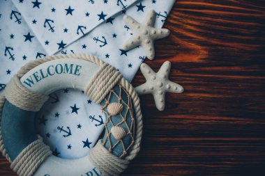 Lifebuoy, denizyıldızı ve ahşap kahverengi arka planda çapa izi kumaşı. Yaz mevsimi