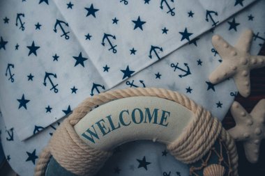 Lifebuoy, denizyıldızı ve ahşap kahverengi arka planda çapa izi kumaşı. Yaz mevsimi