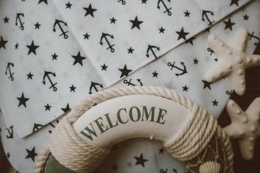 Lifebuoy, denizyıldızı ve ahşap kahverengi arka planda çapa izi kumaşı. Yaz mevsimi