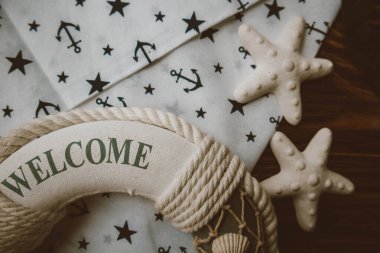 Lifebuoy, denizyıldızı ve ahşap kahverengi arka planda çapa izi kumaşı. Yaz mevsimi