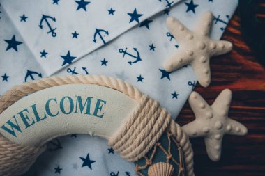 Lifebuoy, denizyıldızı ve ahşap kahverengi arka planda çapa izi kumaşı. Yaz mevsimi