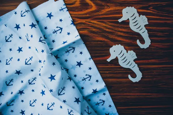 Kumaşa dayanak noktası, ahşap kahverengi arka planda denizatları.