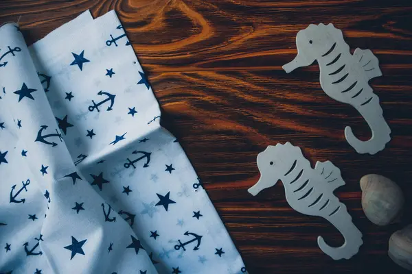 Kumaşa dayanak noktası, ahşap kahverengi arka planda denizatları.