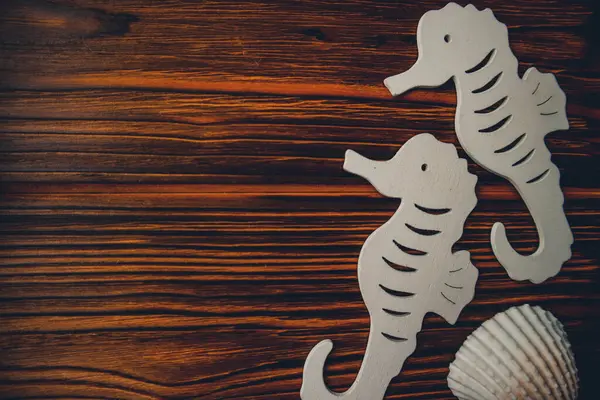 Kumaşa dayanak noktası, ahşap kahverengi arka planda denizatları.