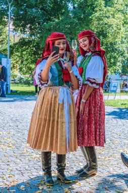 Uherske Hradiste, Çek Cumhuriyeti - 11 Eylül 2021 Uherske Hradiste 'de şarap festivali, şarap, halk dansları, gelenekler. Halk kostümü giymiş iki kız. Uherske Hradiste 'deki Folklor Festivali