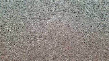 Yumuşak bej tonlarda ince ve pürüzlü bir duvar yüzeyi. Yüzey biraz pürüzlü görünüyor, renk ve dokudaki değişkenleri gösteriyor.