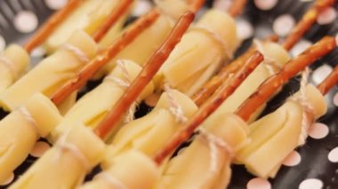 Peynirle doldurulmuş biberli jalapeno mumyaları, Cadılar Bayramı atıştırması. Eğil. Gratin peyniri. Siyah ve turuncu arka plan. Büyüt.