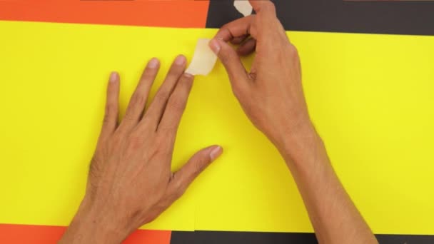 用睫毛膏胶带把两块黄色的纸板连在一起 棕色皮肤的手 手工艺和造型艺术 — 图库视频影像