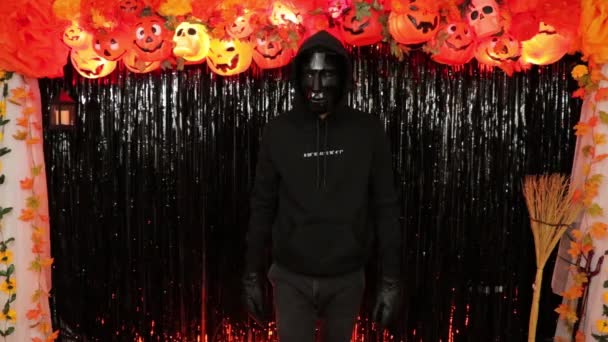 不気味な3D多角形のマスクと黒の衣装の人 ハロウィンのテーマパーティー 秋の装飾 — ストック動画