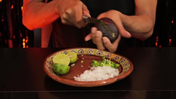 拉丁裔男人为他的万圣节派对准备了鳄梨酱 用简单的方法拆开鳄梨黑色背景 — 图库视频影像