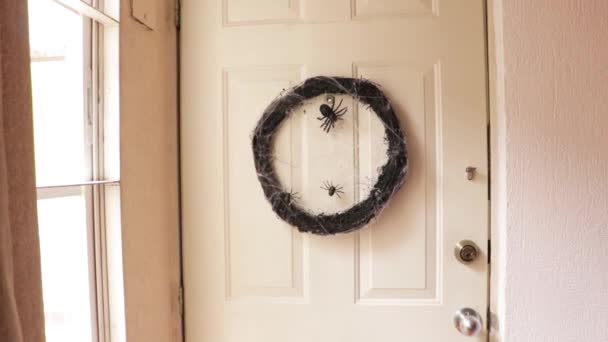 ハロウィーンのための不気味な装飾 ドアにぶら下がっているクモとクモの巣のある乾燥した枝の暗い花輪 — ストック動画