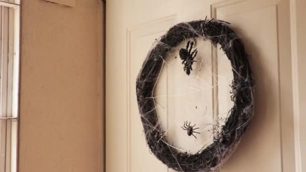 ハロウィーンのための不気味な装飾 クモの巣がドアにかかって乾燥した枝の暗い花輪 — ストック動画