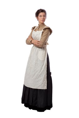 Önlük giymiş, kollarını kavuşturmuş, beyaz arka planda soyutlanmış genç bir çayır kadını başka tarafa bakıyor.