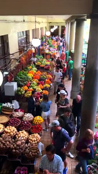 地元の人や訪問者が新鮮な農産物のカラフルな配列に没頭し 活発なインタラクションをキャプチャするFunchalの賑やかなフルーツマーケットの雰囲気を撮影する鮮やかなビデオ — ストック動画