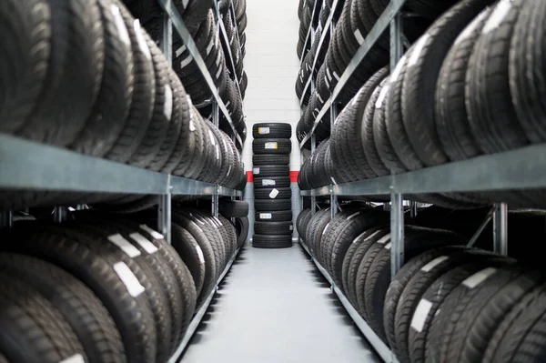 汽车售后服务库房新装轮胎的堆栈架的透视排 — 图库照片