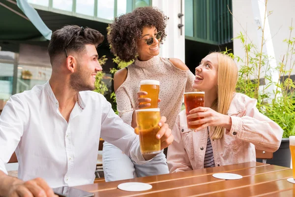 Amigos Multirraciais Positivos Olhando Uns Para Outros Copos Cerveja Enquanto — Fotografia de Stock