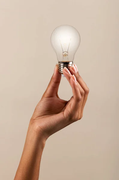 Hand Black Woman Demonstrating Light Bulb Shining Bright Light Beige — Stock Photo, Image