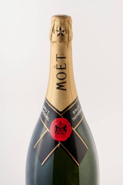 Kapalı bir şişe pahalı Moet Chandon şampanyası. Ziyafet sırasında gri arka plana yerleştirilmiş.