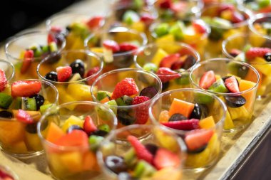 High angle of fruit salad in glass bowls consisting of sliced strawberries kiwi mangoes and grapes