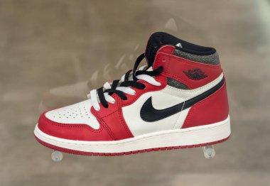 Modaya uygun Nike Air Jordan marka kırmızı, beyaz ve siyah renkli spor ayakkabıları bulanık gri arka plana yerleştirildi
