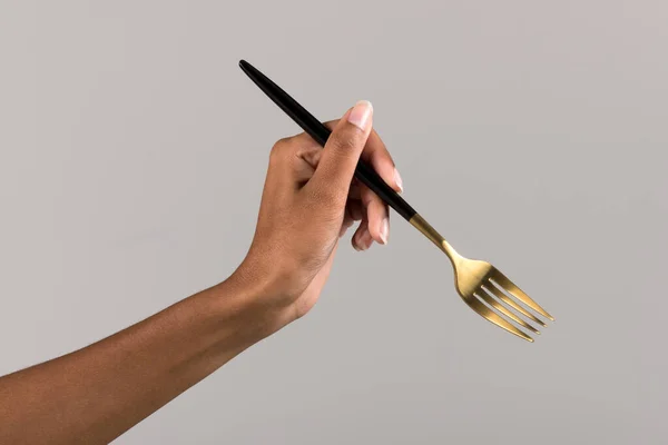 Рука Анонимной Черной Женщины Держит Золотую Вилку Черной Ручкой Сером — стоковое фото