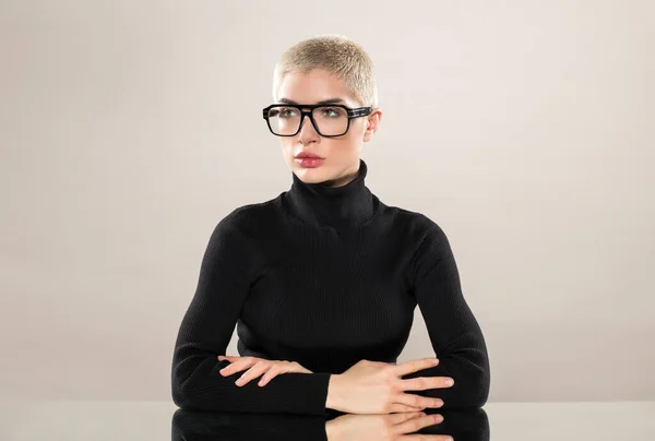 Ernstig Vrouwelijk Model Zwarte Coltrui Bril Kruising Armen Terwijl Zitten — Stockfoto