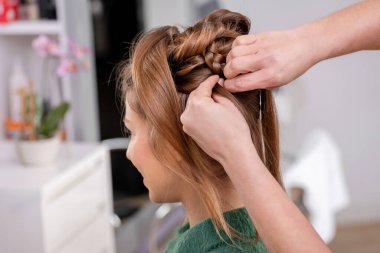 Anonim kadın kuaförün profesyonel güzellik salonunda müşteriye saç kesimi yaparken yan görünümü