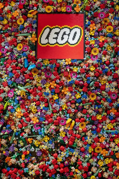 Lego logosu Milan 'daki lego dükkanının içindeki renkli Lego çiçekleriyle kaplı bir duvarda sergileniyor.