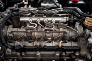 Yakıt enjektörlerinin ve motor bileşenlerinin detaylı görüntüsü modern bir araba motorunun karmaşıklığını gözler önüne seriyor.