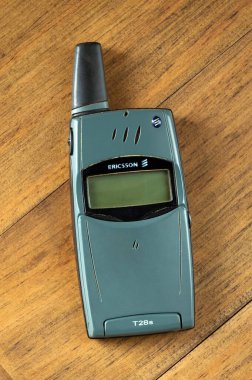 Retro Ericsson T28 'in 1990' ların sonundan kalma cep telefonu ahşap bir yüzeye yerleştirilmiş.