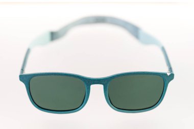 Yeşil mercekli şık turkuaz güneş gözlükleri UV koruması ve şık bir görünüm sunuyor.