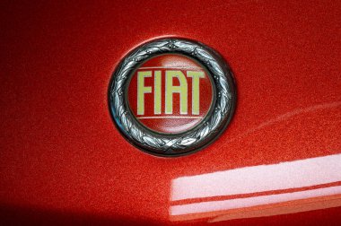 Eski bir Fiat logosunun kapanışı, markanın tarihi amblemini klasik kırmızı bir arabanın üzerinde gösteriyor.