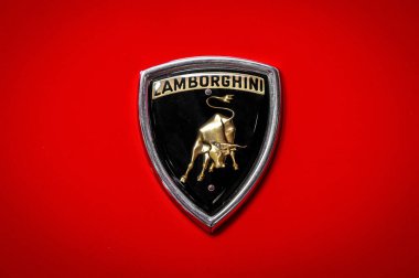 Somma Lombardo, Lombardy, İtalya - 15 Mayıs 2025: Kırmızı klasik bir arabanın üzerinde boğa amblemi olan altın Lamborghini logosunu kapatın