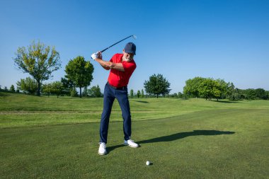 Kıdemli golfçü, güneşli bir günde golf sahasında salıncakta sallanıyor, eğleniyor ve yeteneklerini geliştiriyor.