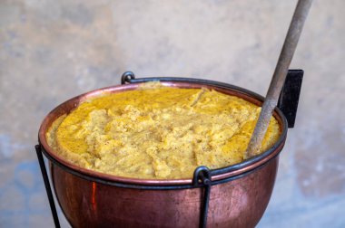 Geleneksel İtalyan yemeği Polenta pişiren bakır tencereye yakın.