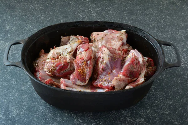 黒鉄鍋で味付け子羊の肉 ローストする準備ができて 暗い石の背景の上 サイドビュー — ストック写真