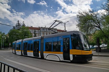 Sofya, Bulgaristan - 19 Nisan 2024: Perlovska nehri üzerinde bir köprü ile otomobiller, tramvay, tramvay rayları ve trafik ışıkları için bir caddesi olan antik binaların arka planına kıyasla kavşak manzarası, Sofya, Bulgaristan. Ziyaret yerinde..