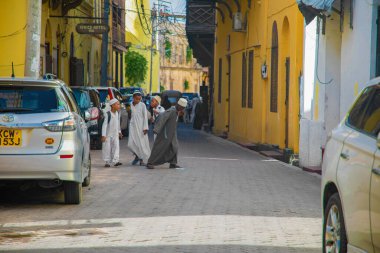 Mombasa, Kenya Afrika. Eski şehrin 19.10.2019 dar sokağında insanlar ve arabalar var. Modern ve eski. Pazar okulunun yakınındaki çocuklar.