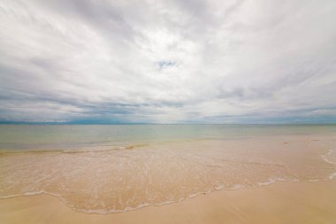 White sand. Bright tropical summer sun and blue sky with light clouds.