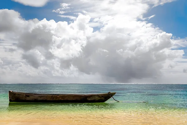 old handmade african  dhow fishing wooden boat anchored in the ocean in sunny weather