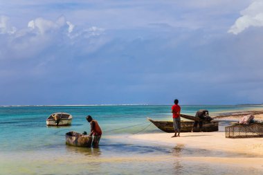 Diani plajı, Mombasa, Kenya. 13 Ekim 2019. Balık tutan mutlu Afrikalı balıkçı okyanusun kenarında duruyor.