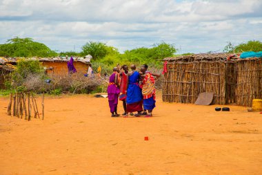 Kenya Afrika, 16 Ekim 2019. Afrika kabilesinden Maasai 'li kadınlar köydeki evlerinde kilden yapılmış ulusal elbiseler giyiyorlar.