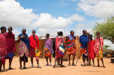 Kenya Afrika, 16 Ekim 2019. Afrika kabilesi Masai 'li erkekler geleneksel köylerinin arka planına karşı tam gelişim içinde.