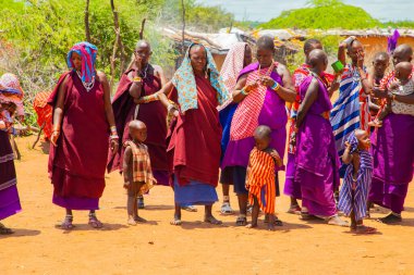 Kenya Afrika, 16 Ekim 2019. Afrika kabilesinden Maasai 'li kadınlar köy evlerinde kilden yapılmış ulusal elbiseler giyiyorlar.